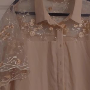 Cream button down blouse with see thru sleeves, chest, and upper-back pieces